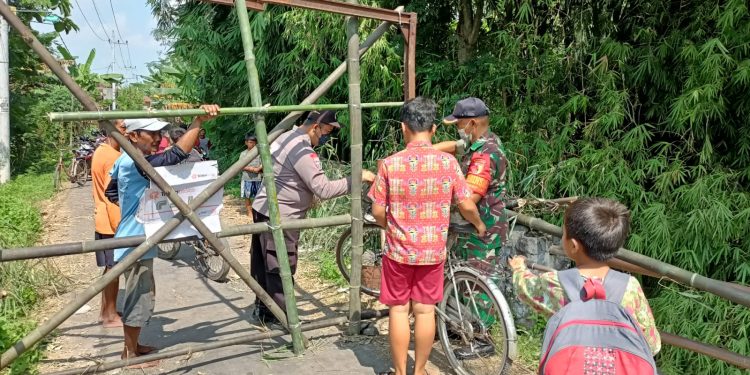 Jembatan Antar Desa Rusak, Anggota Bhabinkamtibmas Bantu Anak Sekolah Menyeberang